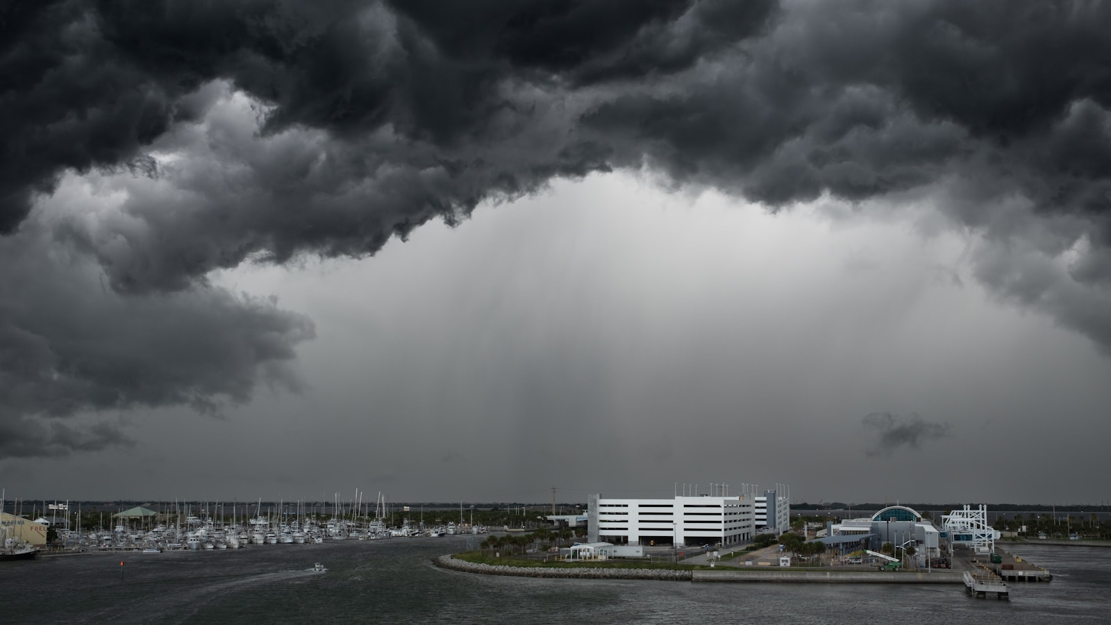 A black and white photo of a storm coming in over a parking lot